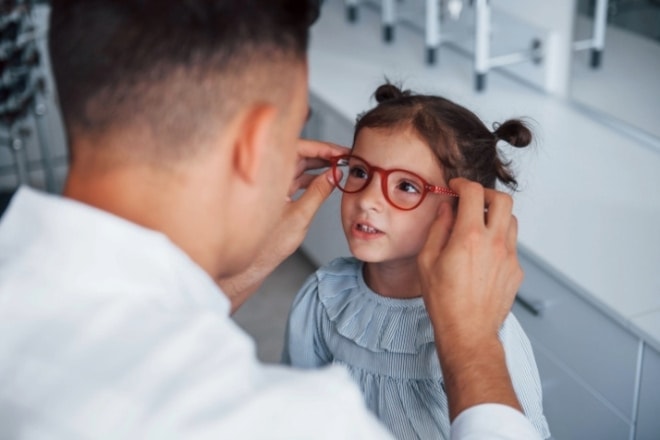 unhappy child with head down next to glasses