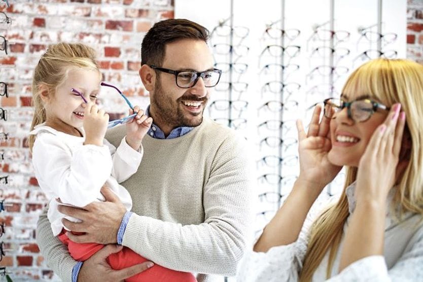 How can I tell if my eyeglass frames fit? Family trying on glasses in store