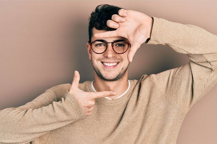 What is my face shape? Use this guide to find out what glasses suit you man framing his face shape with his fingers