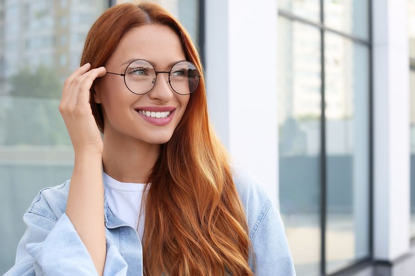 What does the shape of your glasses say about you? woman trying on different glasses frame shapes