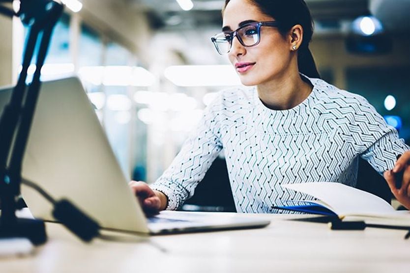 woman wearing photochromic eyeglasses as computer glasses at work