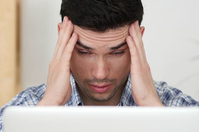 Will computer glasses reduce digital eye strain? man with computer eye strain looking at laptop screen