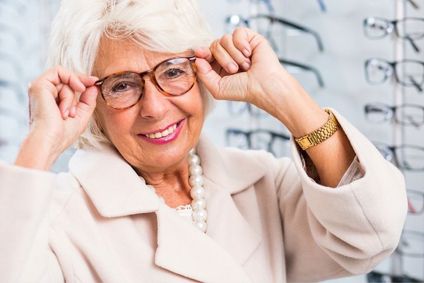 Reading glasses vs. multifocal glasses: Which ones should you get? older woman trying on reading glasses and multifocals