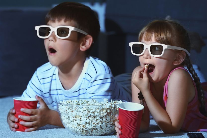 3D glasses: A brief guide kids with popcorn watching a movie wearing 3d glasses