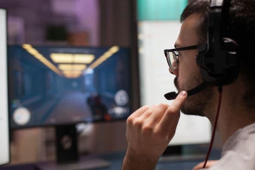 Do gaming glasses really work? Yes, they do… but not for everyone. Man wearing eyeglasses and a headset while playing a video game