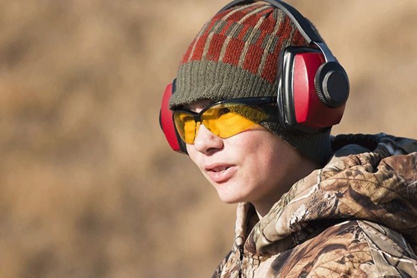Finding the best prescription shooting glasses to protect your eyes boy wearing noise-canceling headset and prescription shooting glasses