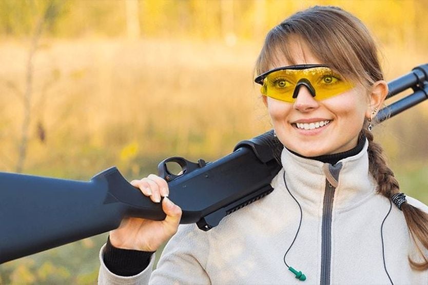 Shooting glasses and hunting eyewear woman wearing shooting glasses and holding gun