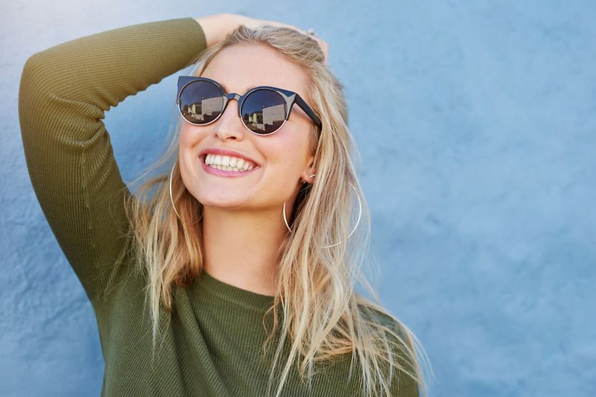 How to pick the best sunglasses for your face shape Woman wearing sunglasses