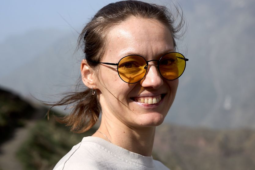 Can sunglasses also filter blue light? woman wearing yellow tinted sunglasses to protect her eyes from blue light