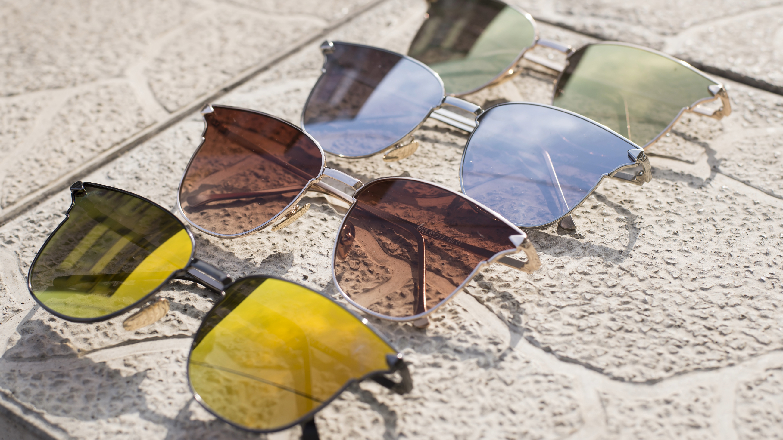 different colored sunglass lenses on concrete