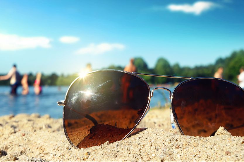 Do photochromic lenses filter blue light? Sunglasses with uv protection lying in the sand
