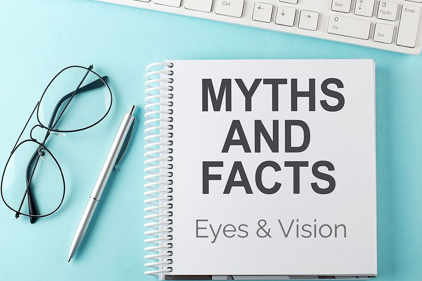 myths and facts about eyes and vision handbook next to keyboard and eyeglasses