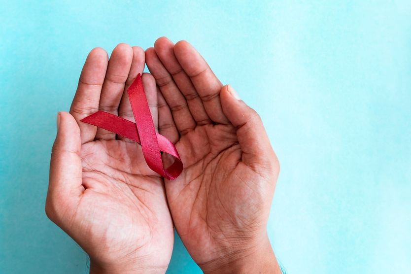 hands hold red ribbon for stroke awareness month