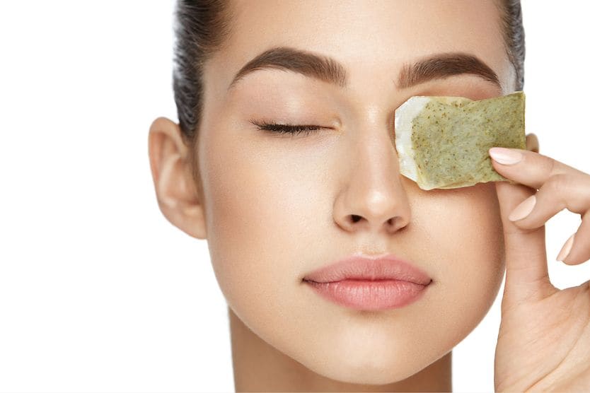 Woman using tea bags as cool compresses for her eyes