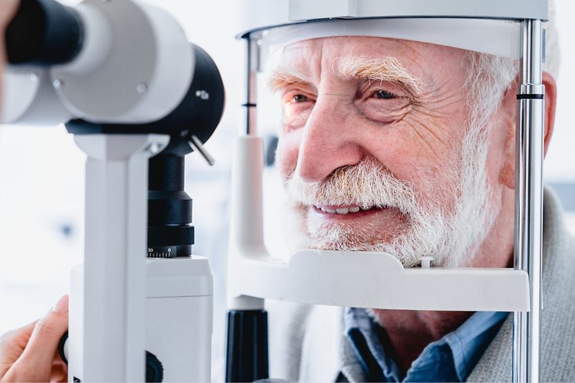 YAG laser capsulotomy: Procedure, cost and risks man getting eyes examined at eye doctor.
