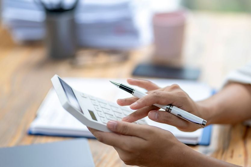 Vision insurance: How it can save you money A woman is using a calculator and pen on a desk.