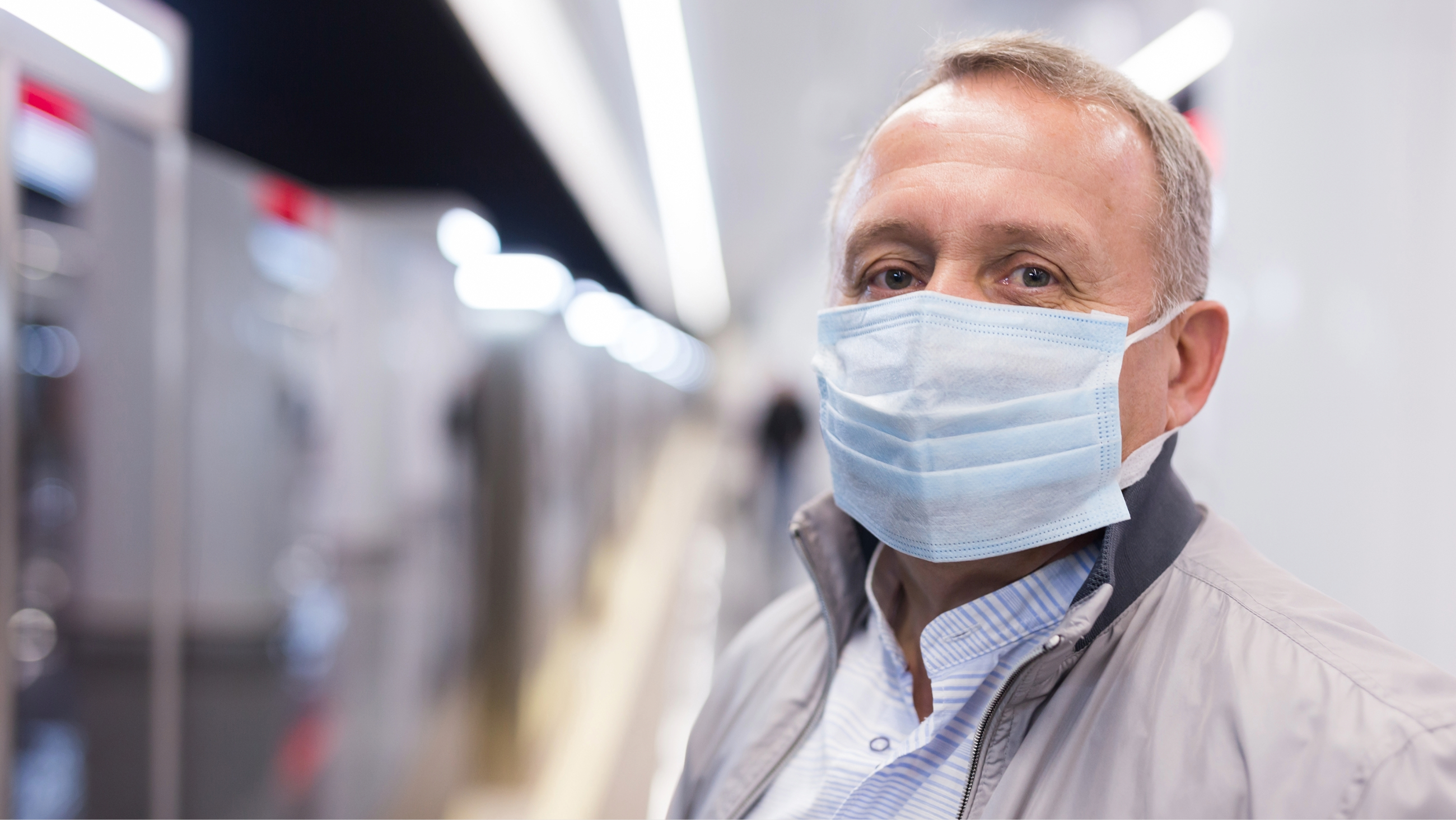 Uomo che indossa una mascherina in pubblico, a testimonianza delle preoccupazioni per la salute degli occhi e la sicurezza durante la pandemia di COVID-19.