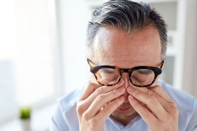 Uomo che strofina gli occhi per il dolore agli occhi