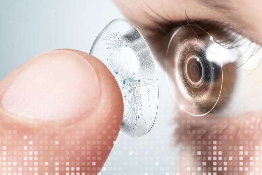 Woman putting a smart contact lense into her eye.