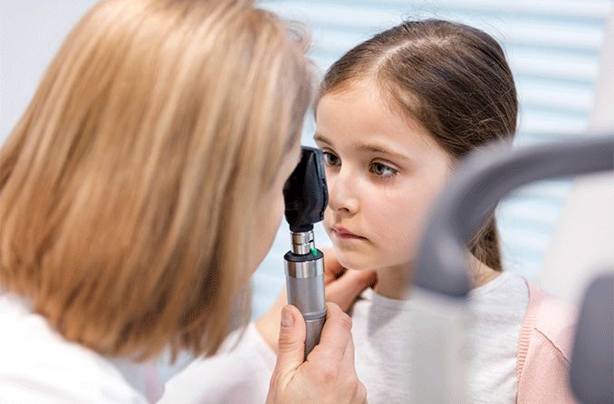 girl with nystagmus getting eyes checked by eye doctor