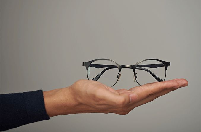 hand holding a pair of eyeglasses ready to donate