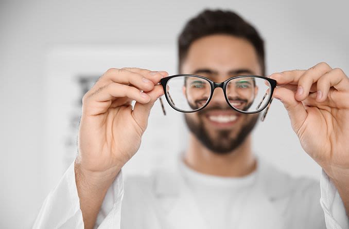 eye doctor holding up a pair of eyeglasses