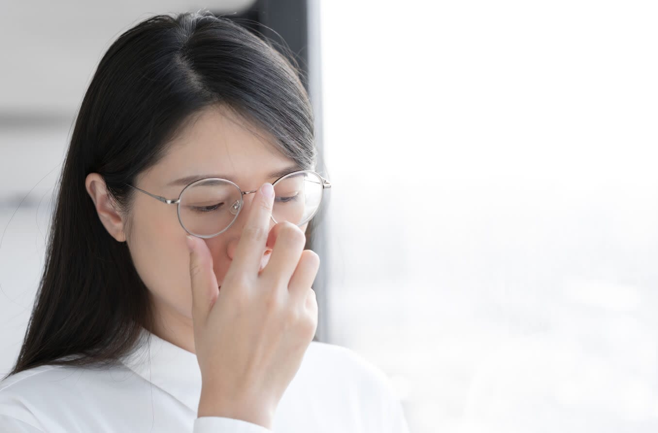 Asian woman pushes up her glasses.