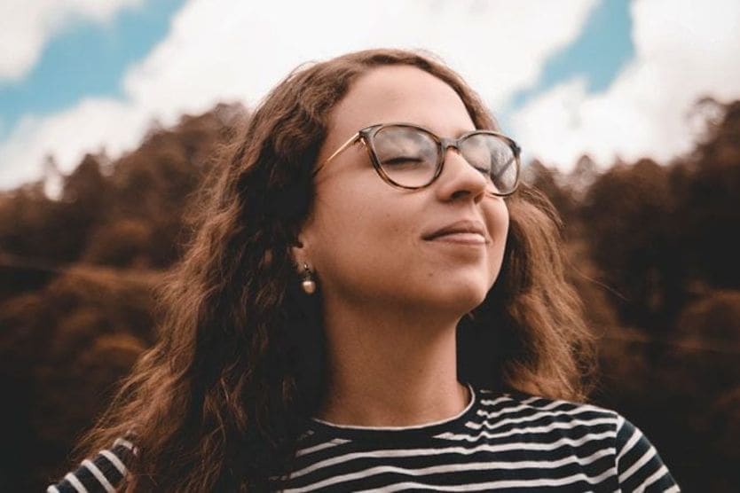 امرأة ترتدي نظارات تستمتع بالشمس على وجهها