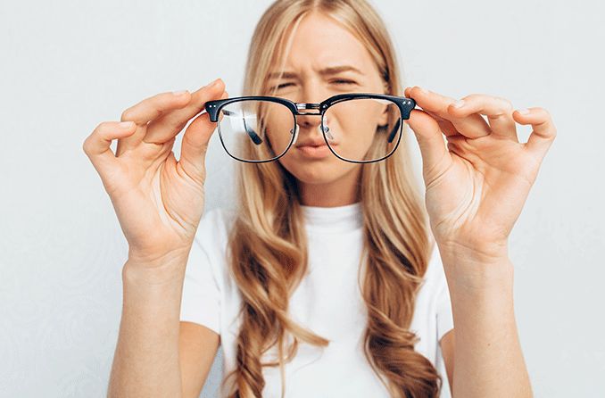 teen girl squinting to see without her glasses