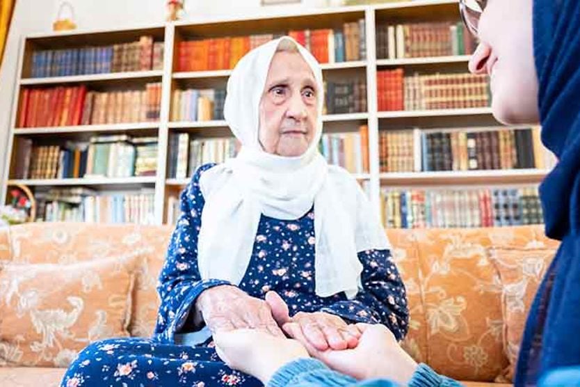 امرأة عجوز تمسك بيد حفيدتها