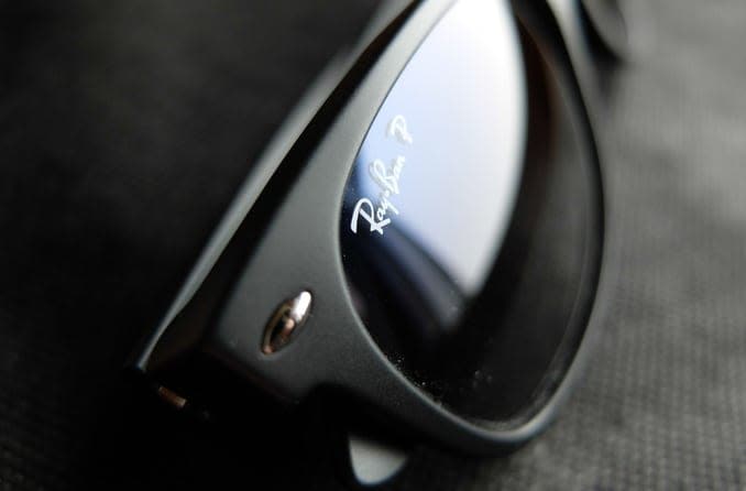 Close-up image of classic black Ray-Ban Wayfarers frame with logo on the lens.