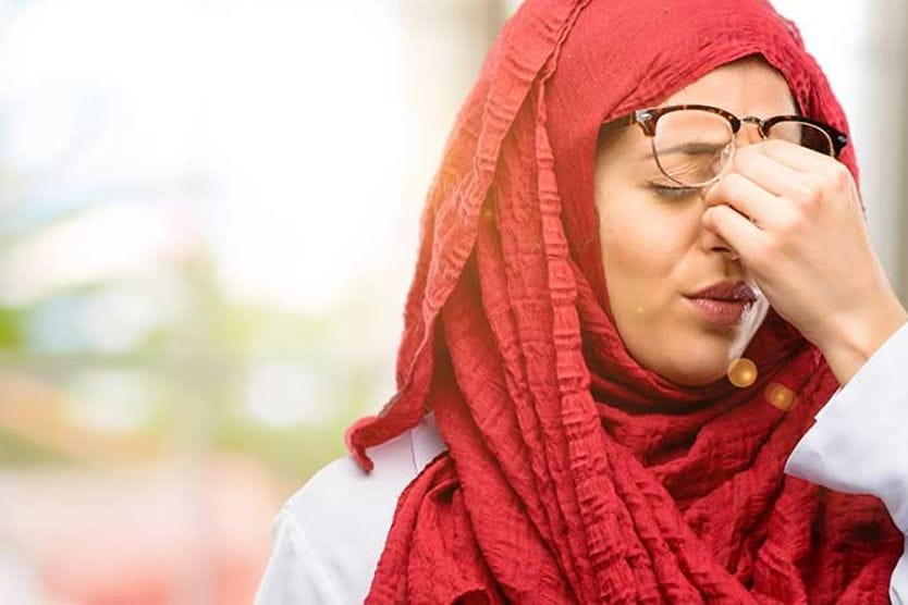 امرأة تفرك عينيها للتعامل مع ارتعاش الجفن.