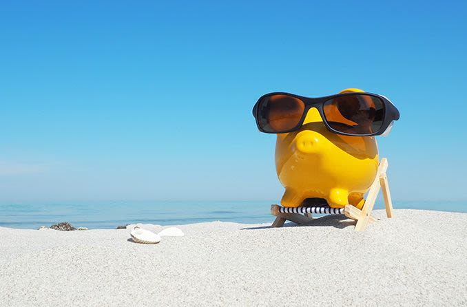 piggy bank wearing sunglasses on the beach