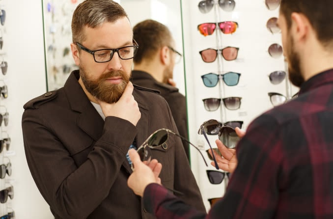 man comparing sunglasses