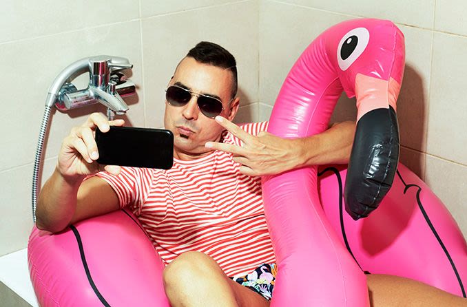 man wearing sunglasses in the tub taking a selfie