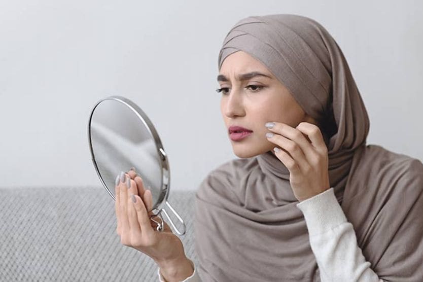 امرأة تنظر إلى عينيها في المرآة في دهشة