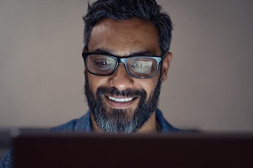 رجل يرتدي نظارات على الكمبيوتر