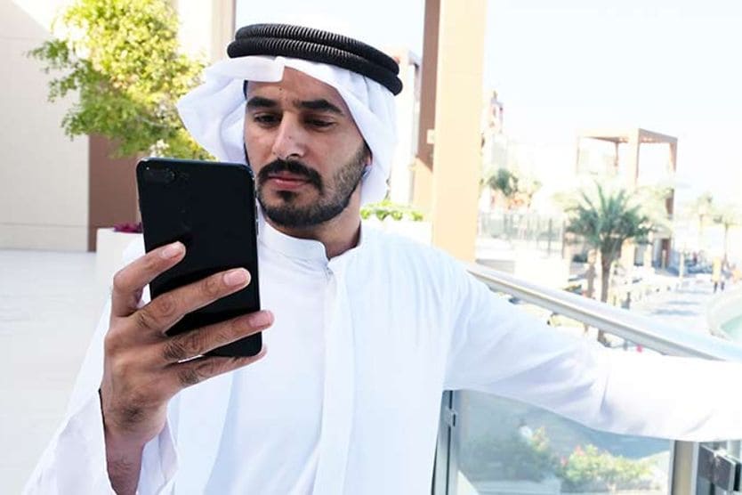 رجل ينظر إلى شاشة الهاتف دون نظارات للقراءة
