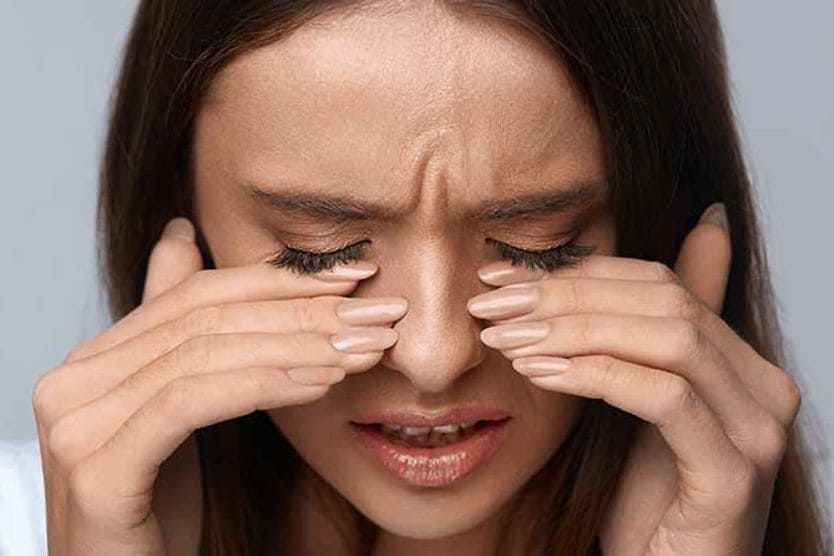 जलन के कारण महिला की आंखों पर उंगलियां होती हैं