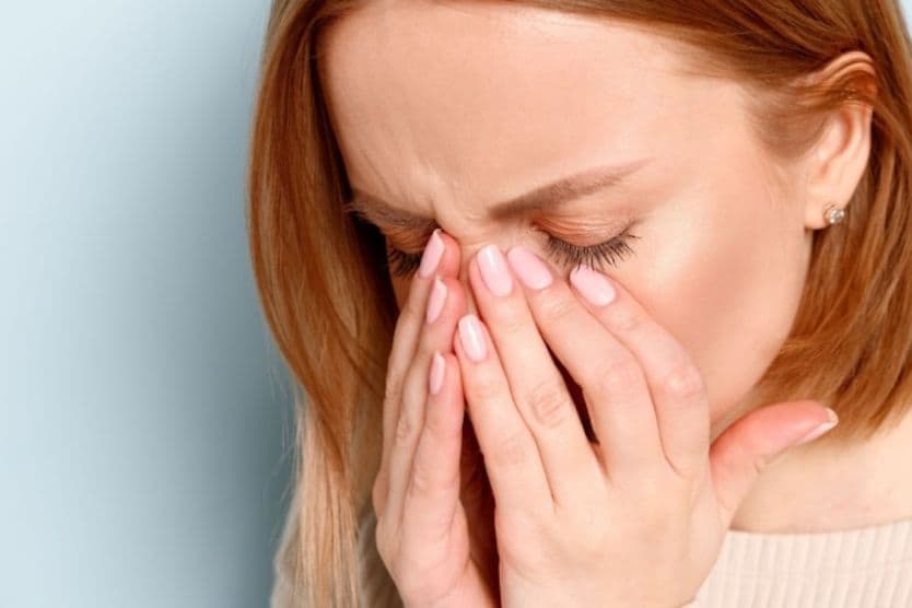 A woman with her eyes closed and hands placed on her face as she looks for a lost contact lens. A woman with her eyes closed and hands placed on her face as she looks for a lost contact lens.