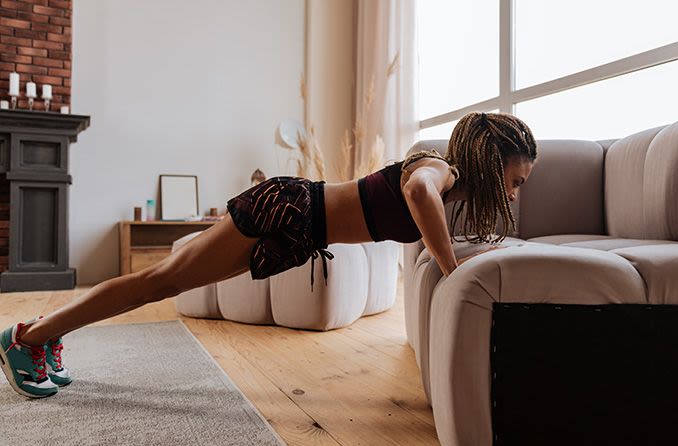 woman doing pushups on her couch