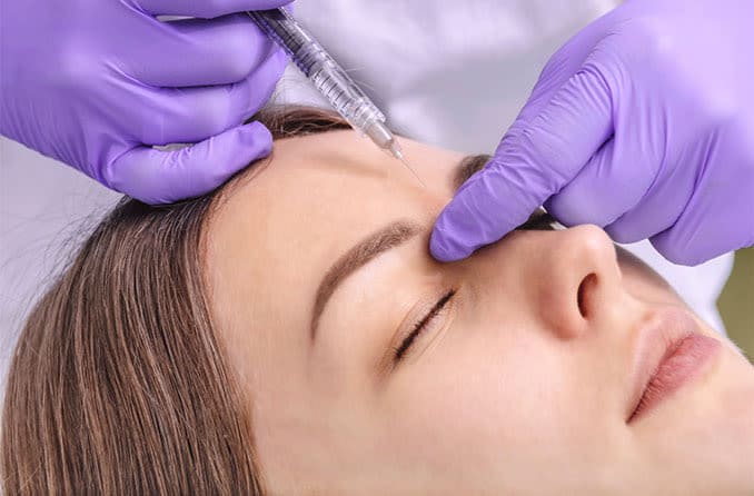 woman getting botox injections near eyelids