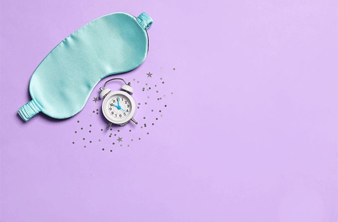 eye mask and an alarm clock on a lavender background