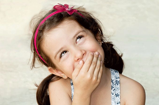 lying young girl looking up and covering her mouth