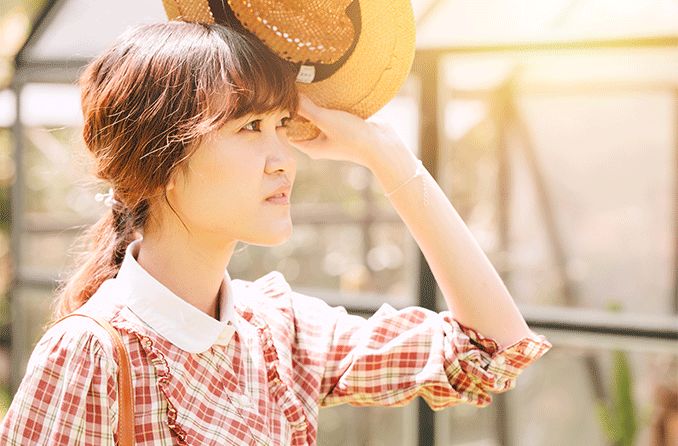 woman with eye cancer shielding her eyes from the bright sun