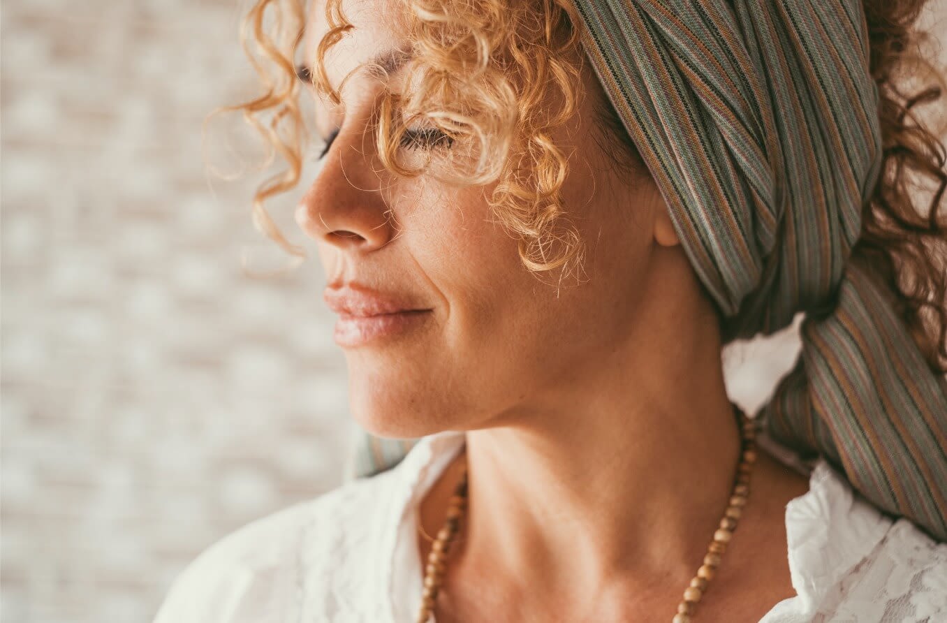 Woman closing her eyes with a peaceful look on her face