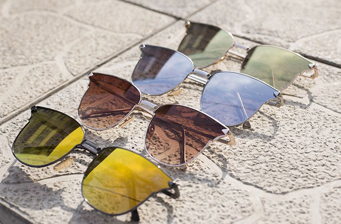 different colored sunglass lenses on concrete