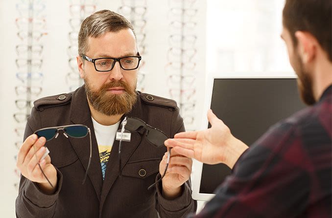 optician helping customer decide between photochromic sunglasses vs polarized sunglasses