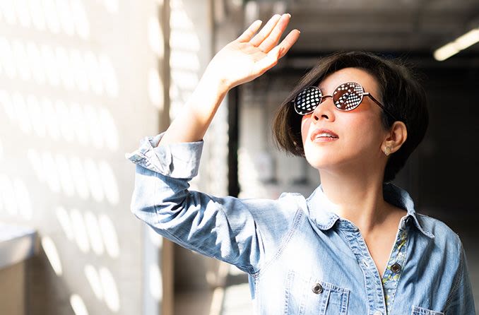 woman wearing uv protected sunglasses shielding her eyes from sun