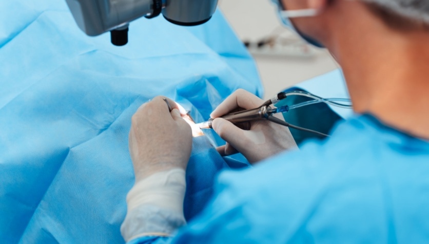 Looking over the shoulder at an eye surgeon performing cataract surgery.